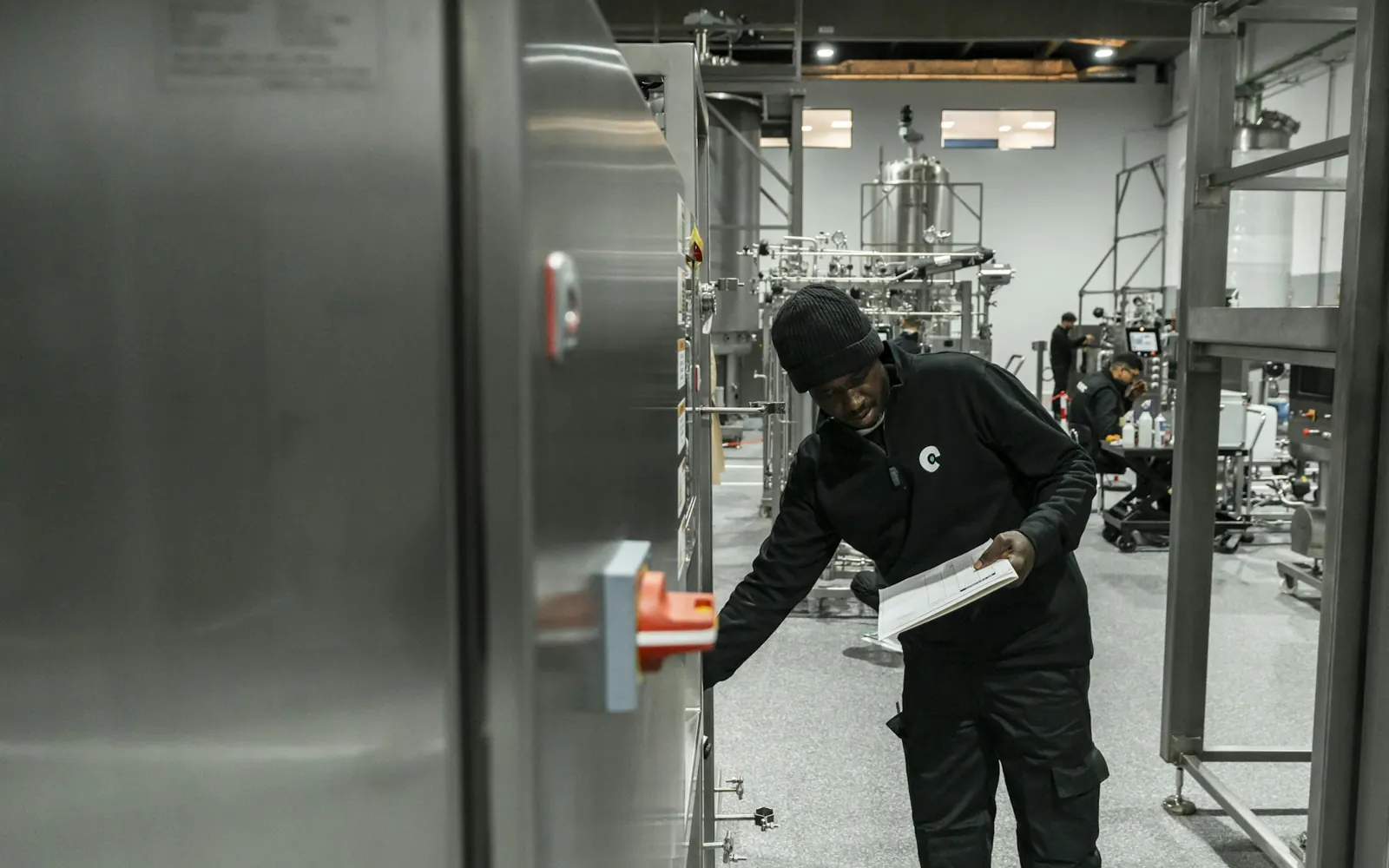 Techniker prüft eine Anlage in einer modernen Produktionshalle