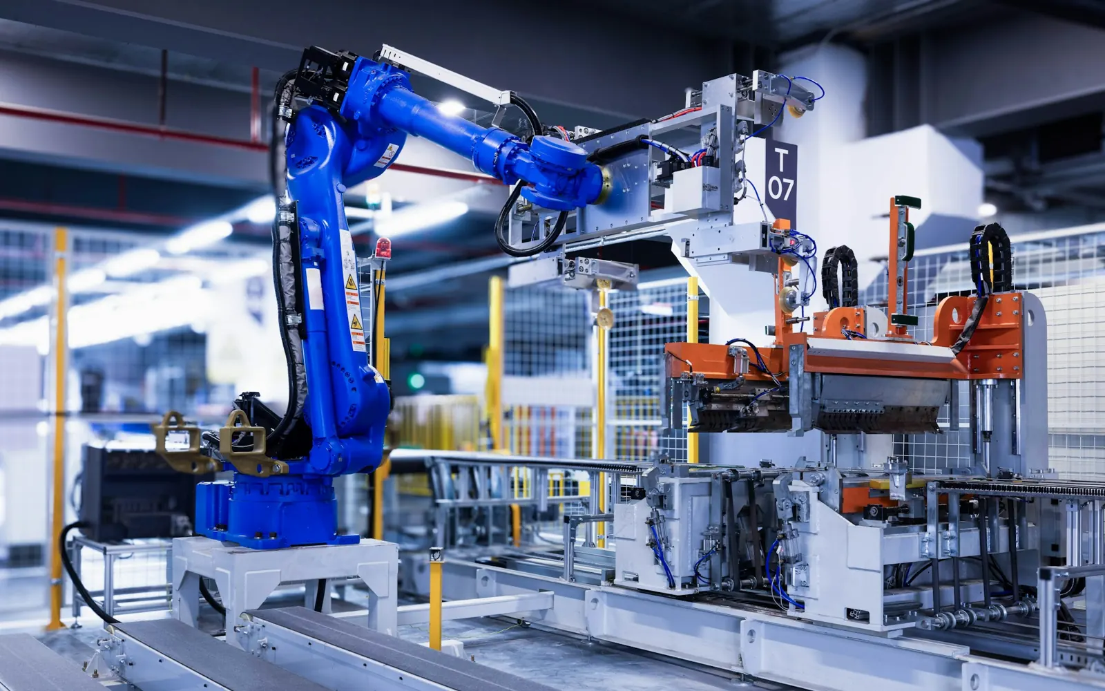 Blauer Industrieroboter an einer automatisierten Fertigungszelle