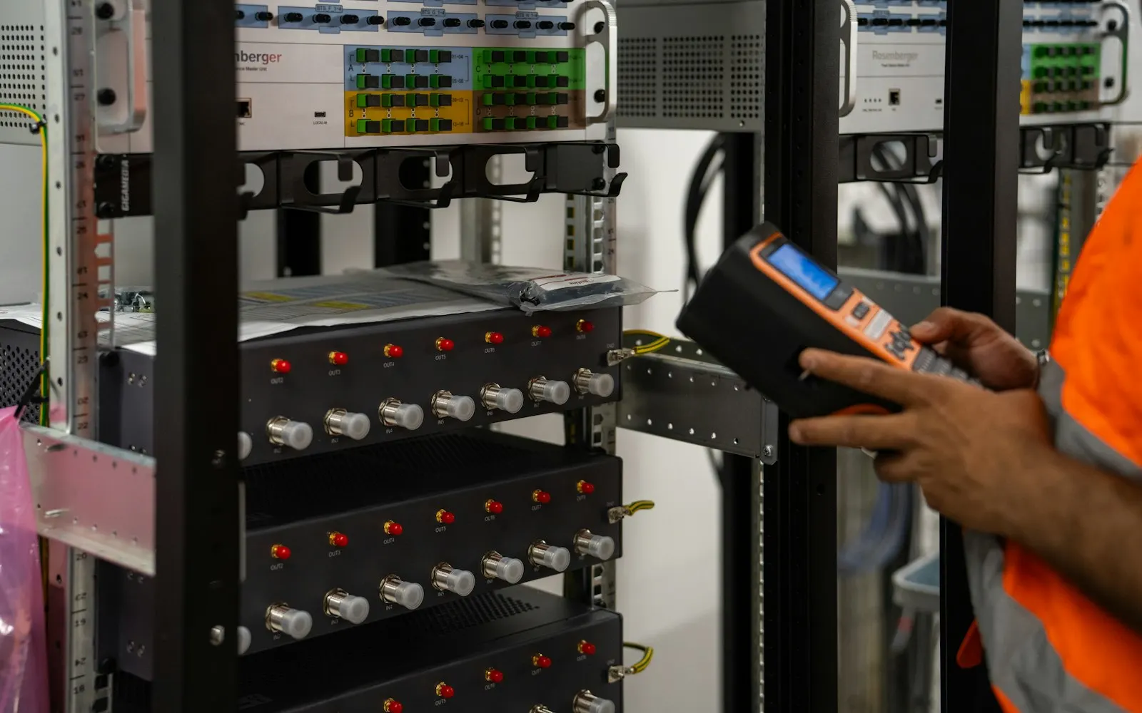 Techniker prüft Netzwerk- und Serverschränke mit einem Diagnosegerät