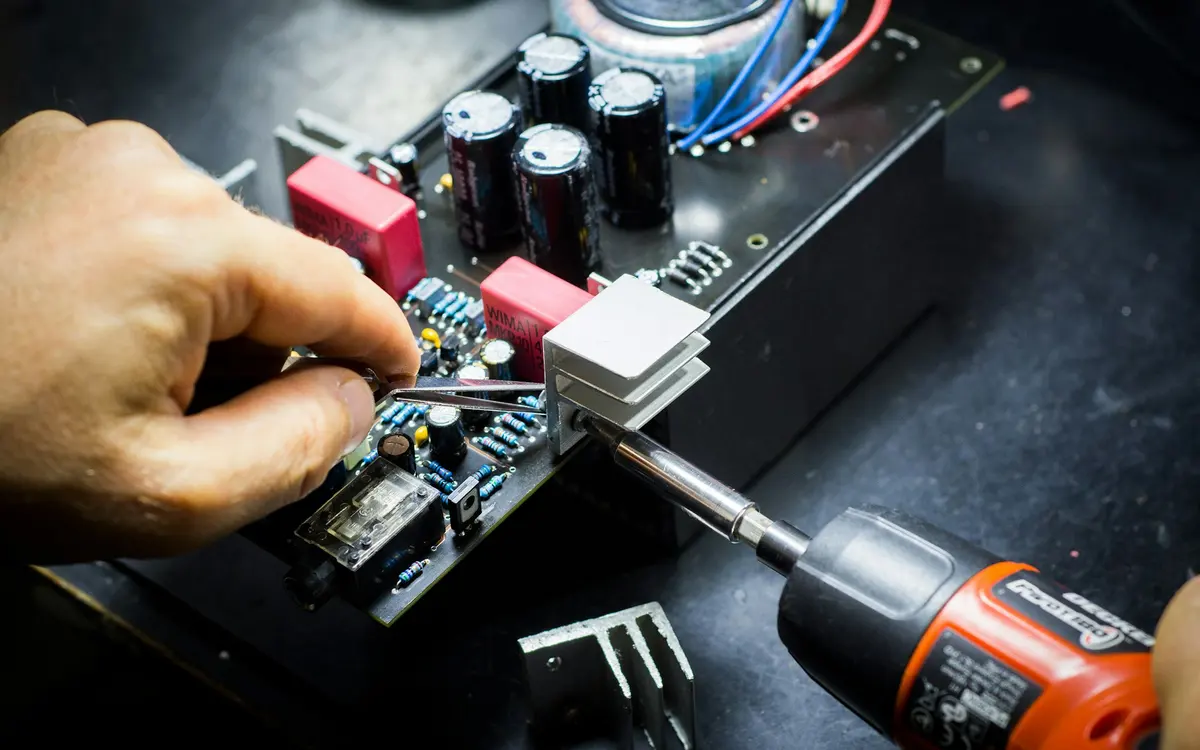 Techniker lötet an einer Elektronikbaugruppe in der Werkstatt