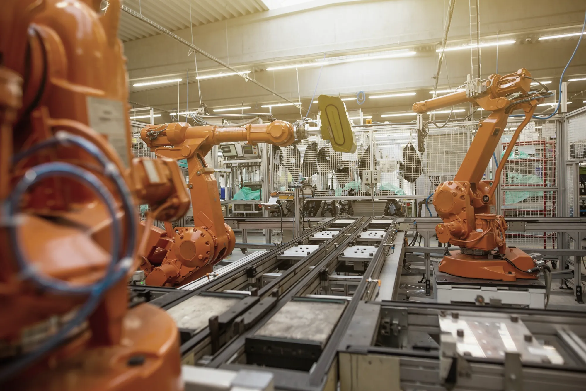 Orangefarbene Industrieroboter an einer automatisierten Fertigungslinie